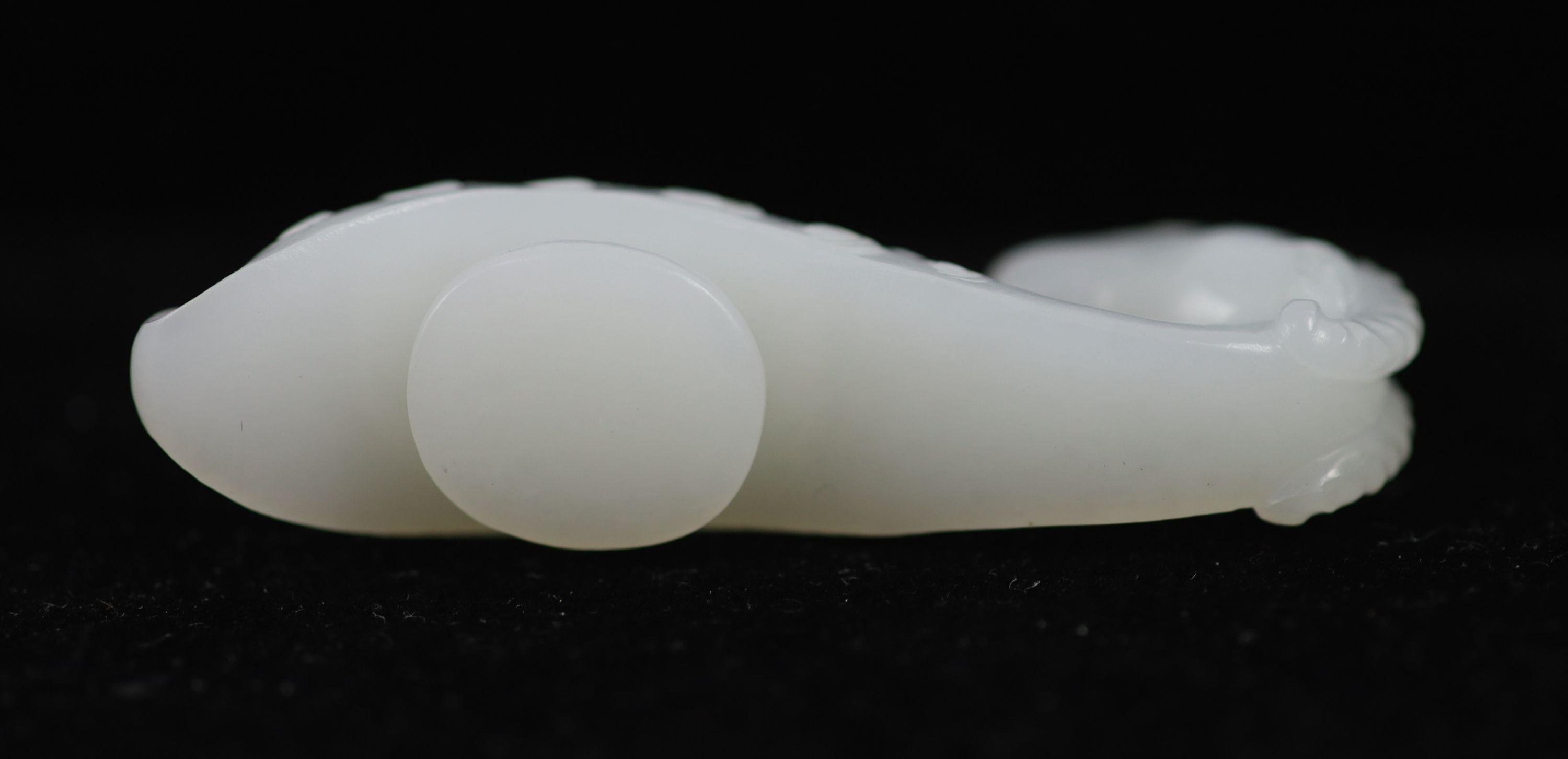 A Chinese white jade 'ram’s head’ belt hook, 6.4 cm long